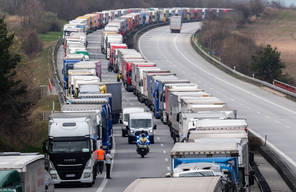 19 March 2020, Saxony, G�rlitz: Policemen drive along on motorcycles between trucks, which jam on the motorway A4 Dresden - G�rlitz near G�rlitz. Thousands of truck drivers have to hold out in a traffic jam, which has grown to a length of about 40 kilometers, before the border with Poland. The border police in Poland has reacted to the long traffic jams due to the new controls at the German-Polish border and opened four more crossings for car traffic, including in Zgorzelec (G�rlitz). Photo: Robert Michael/dpa-Zentralbild/dpa